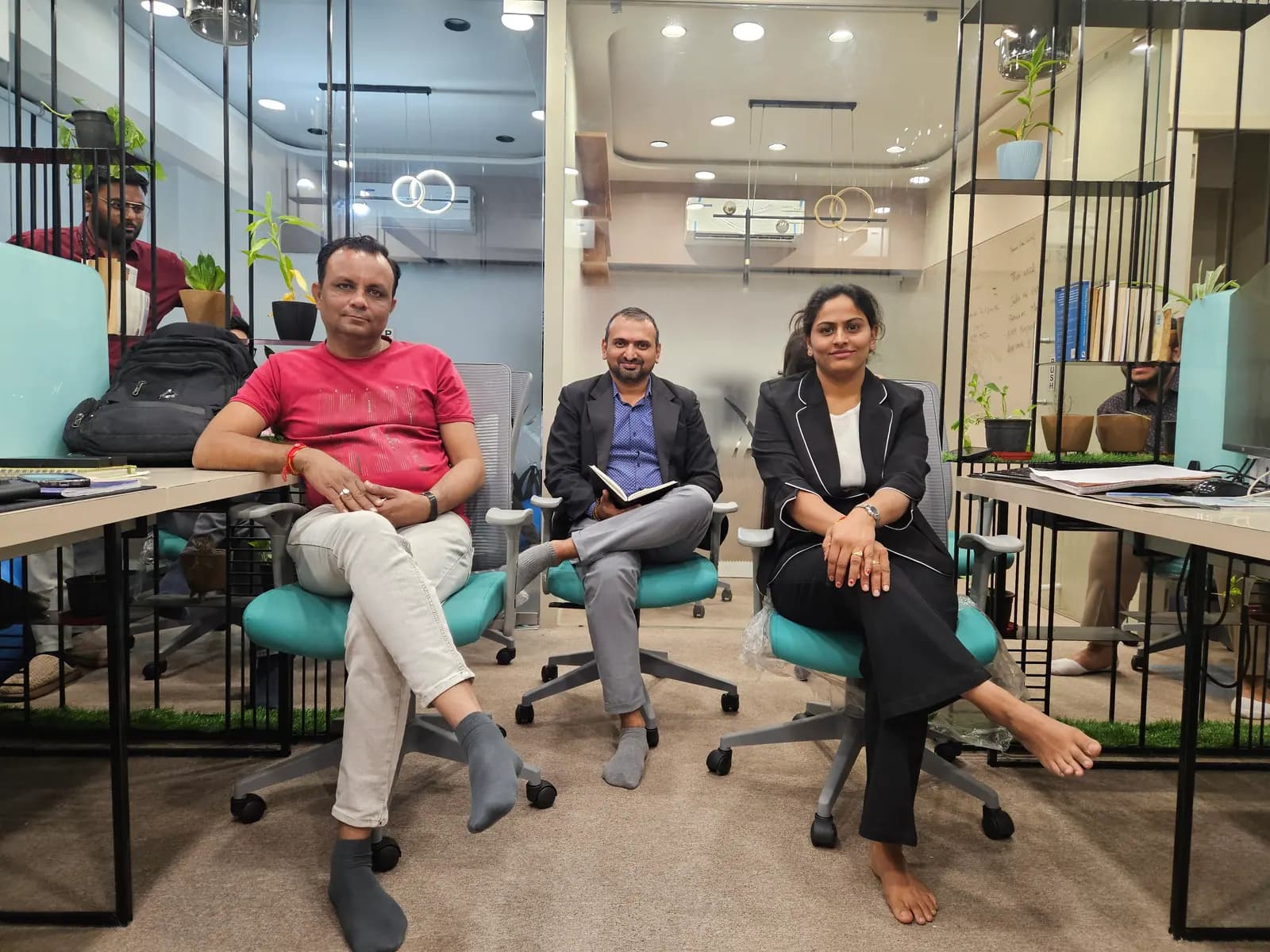 Colleagues sitting together on teal chairs in the Gothi Tech open-plan office