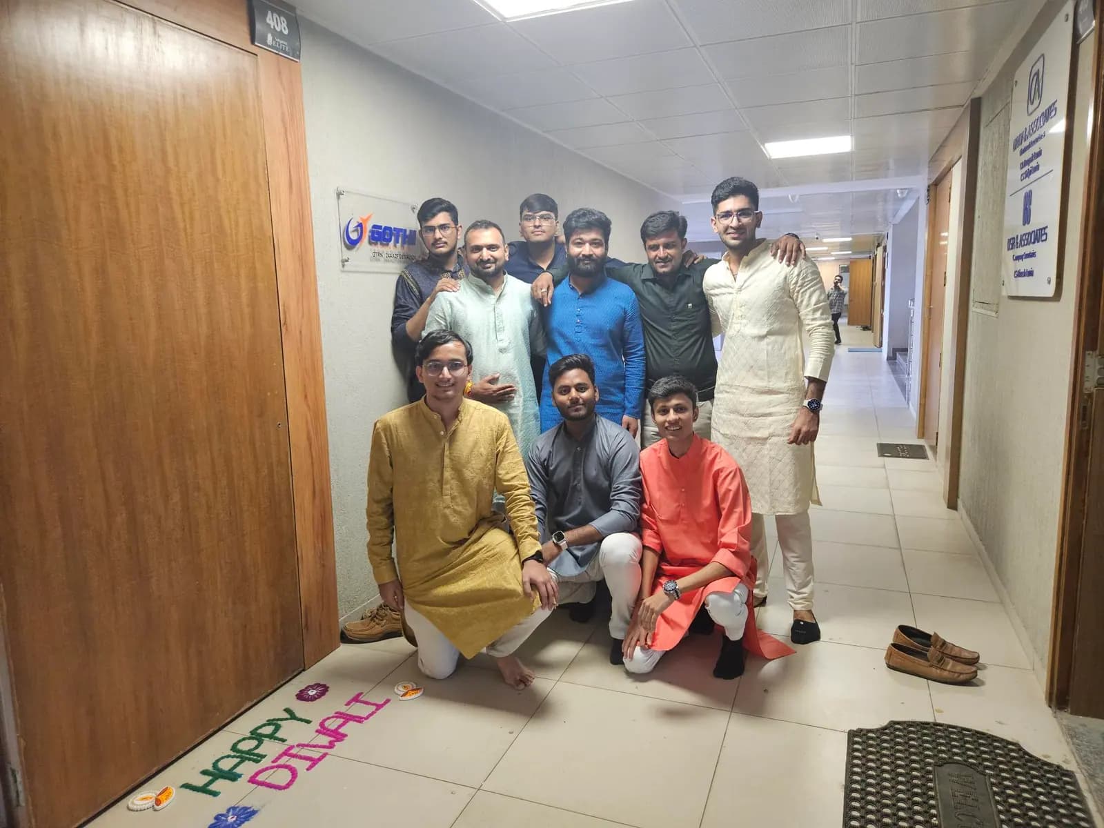 Team members wearing traditional kurtas in the office corridor during a festival celebration
