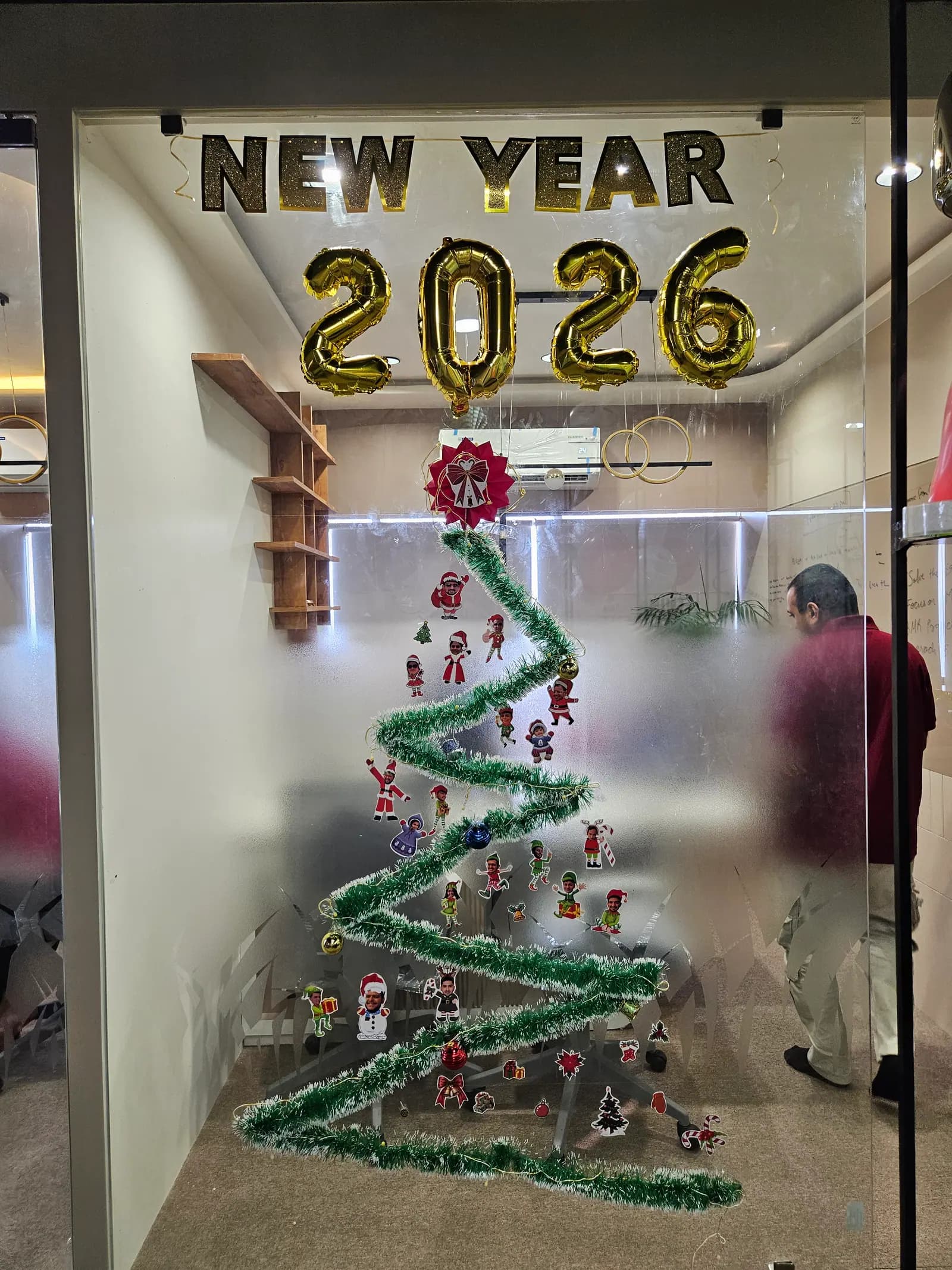 The office decorated with a tinsel tree and gold foil balloons for a New Year celebration