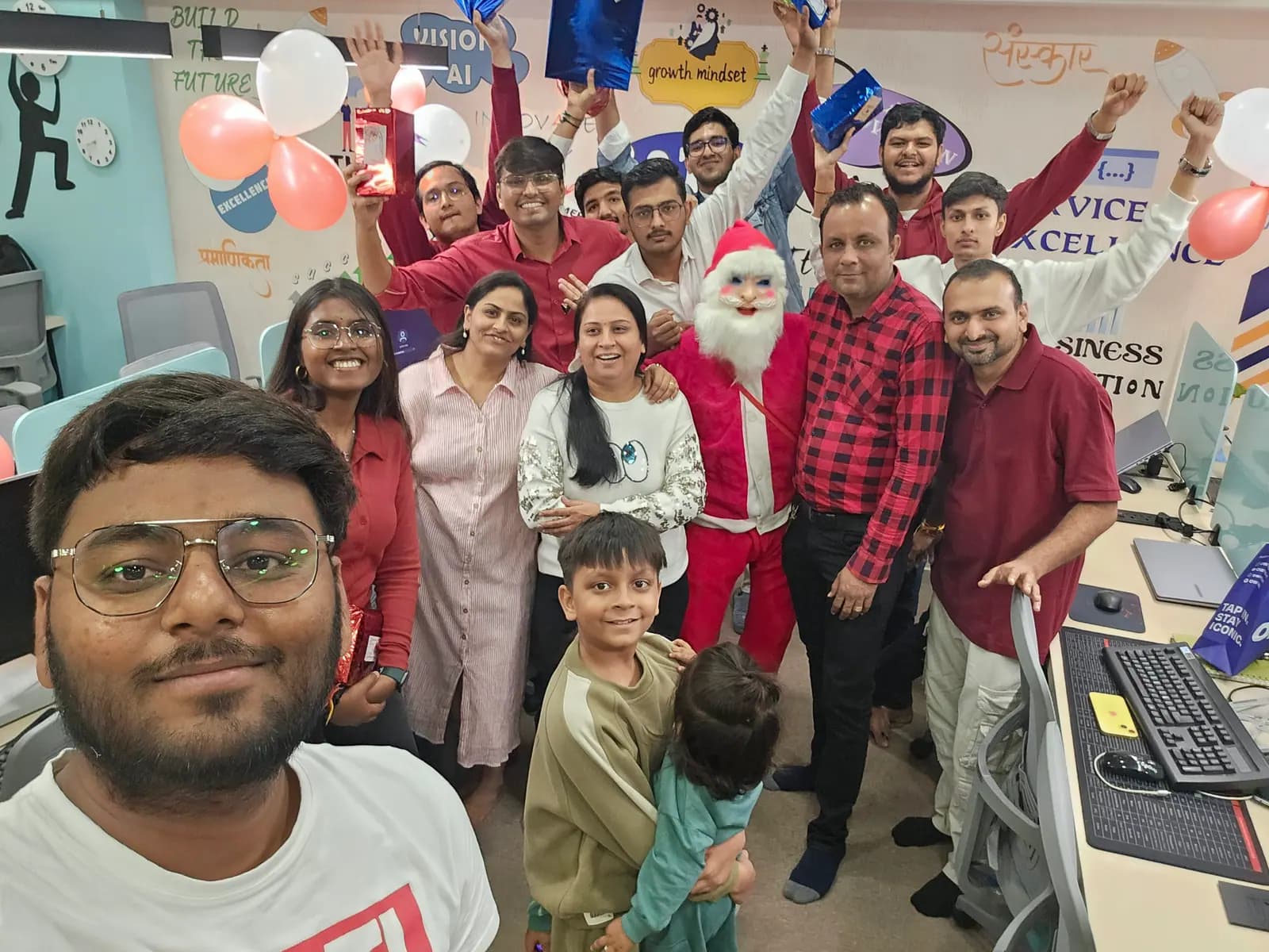 Team members in red at the office Christmas party, one colleague dressed as Santa