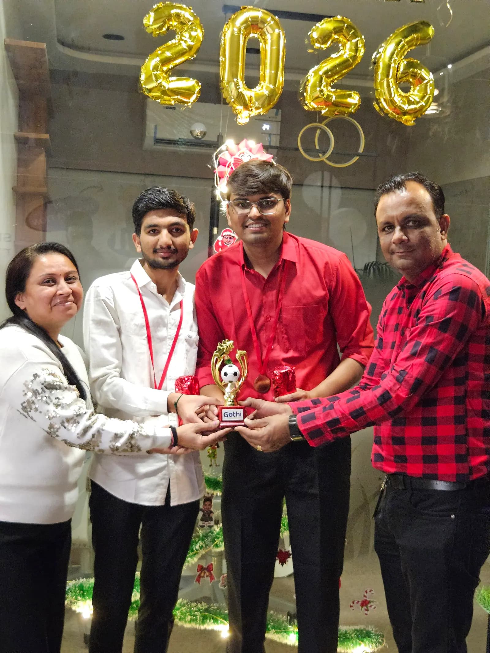 Three colleagues holding up a trophy together at an internal awards moment
