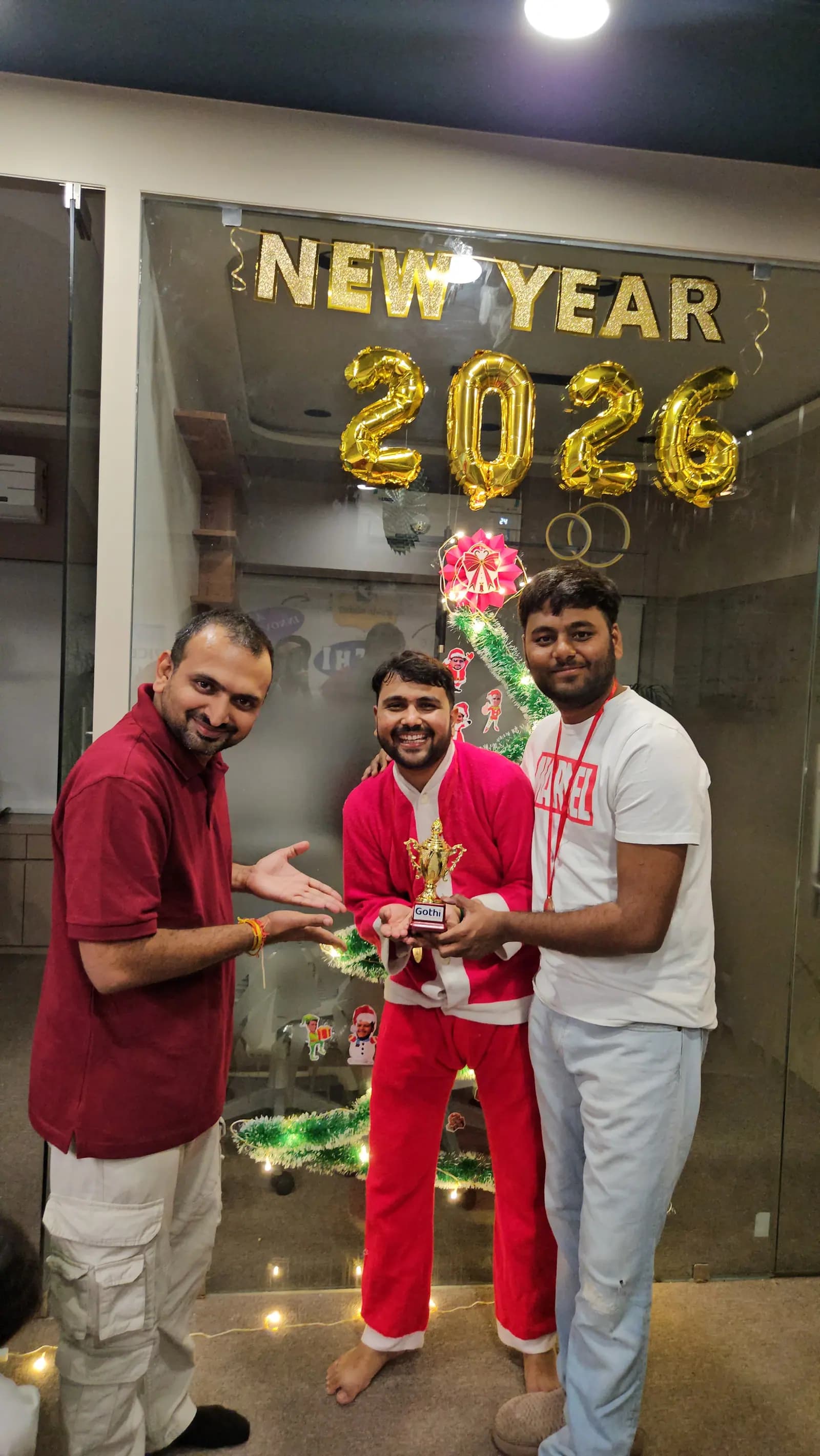 A team member being handed a trophy in front of a balloon-decorated backdrop