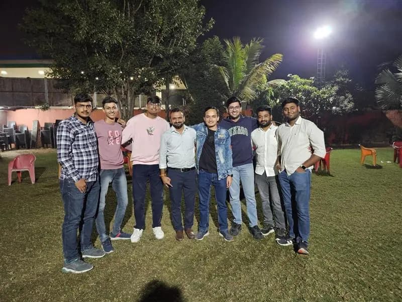 The team standing together on a lawn during an evening offsite